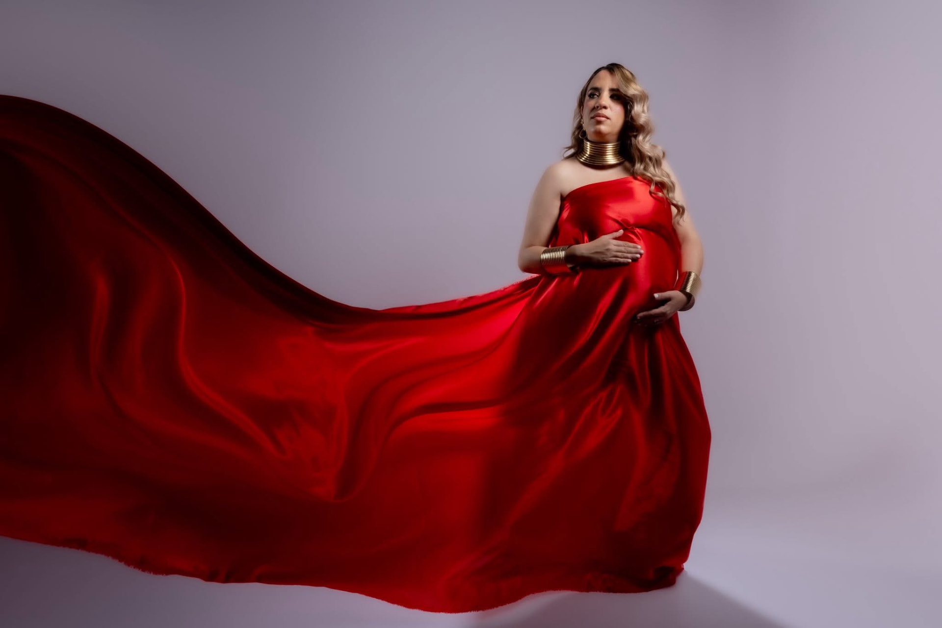 Sesión de maternidad con vestido rojo en movimiento