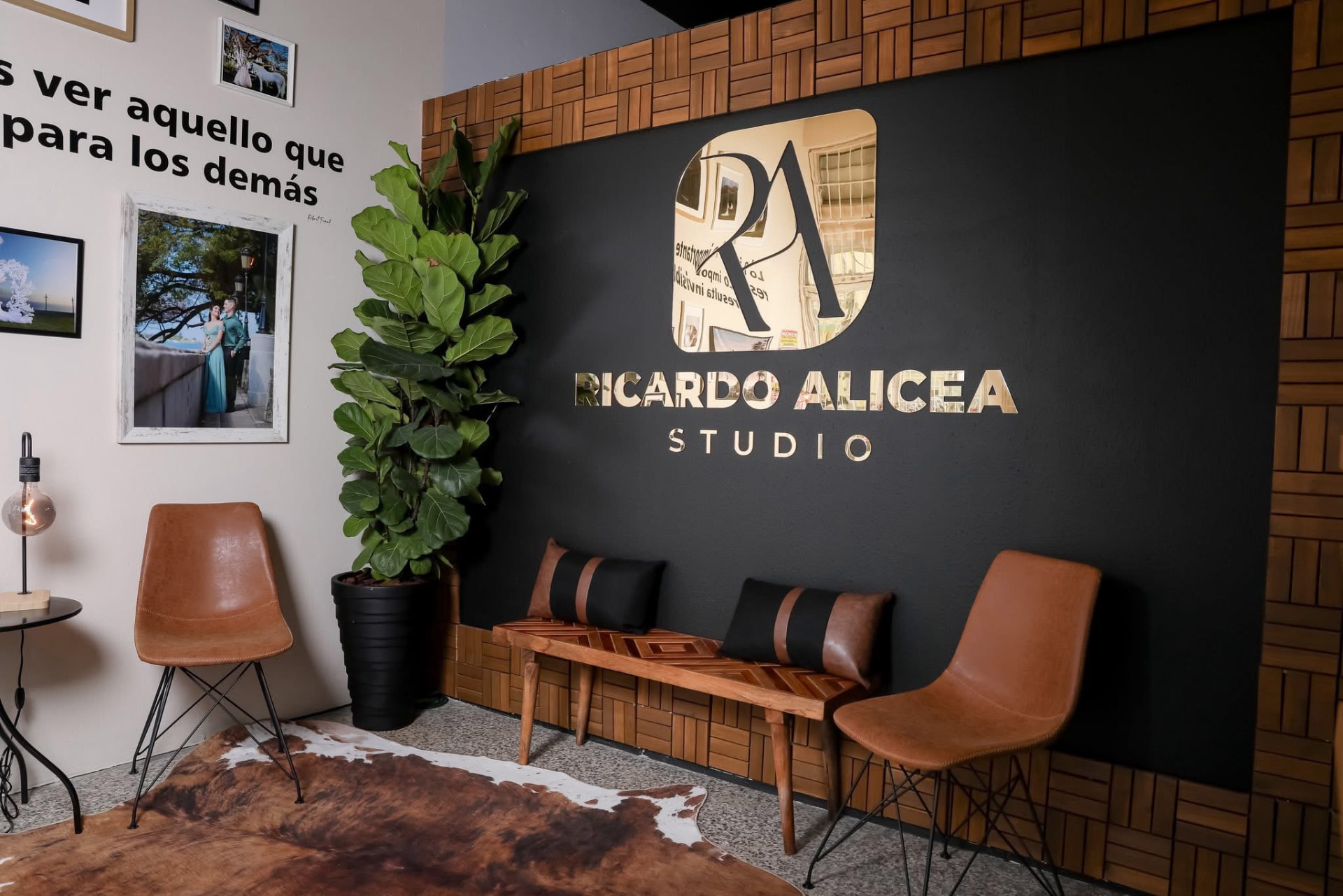 Interior de Ricardo Alicea Studio con pared de madera y logotipo dorado