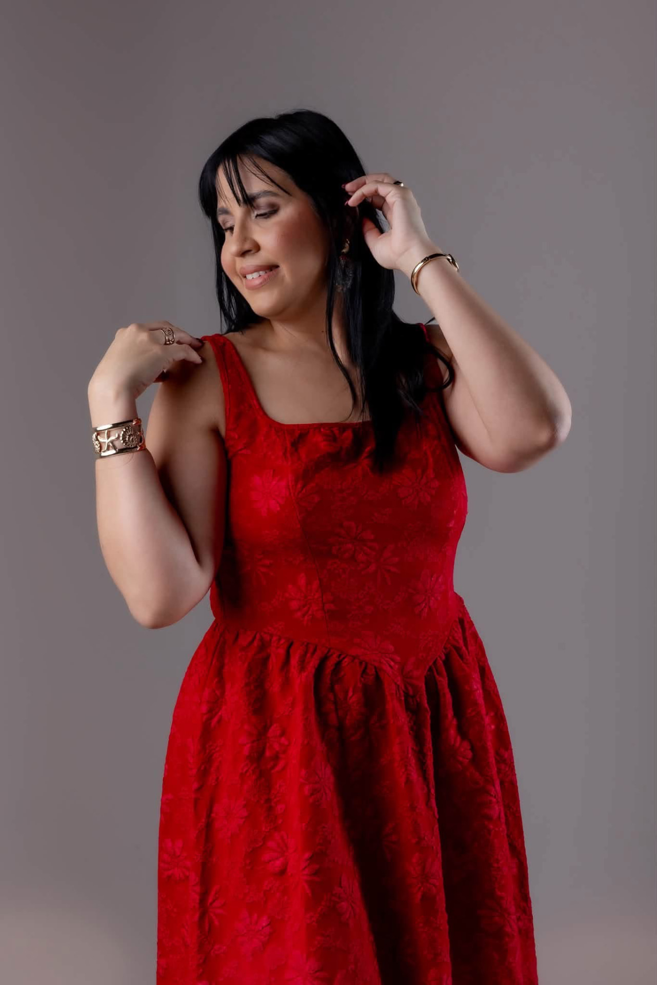 Retrato de mujer con vestido rojo sobre fondo gris